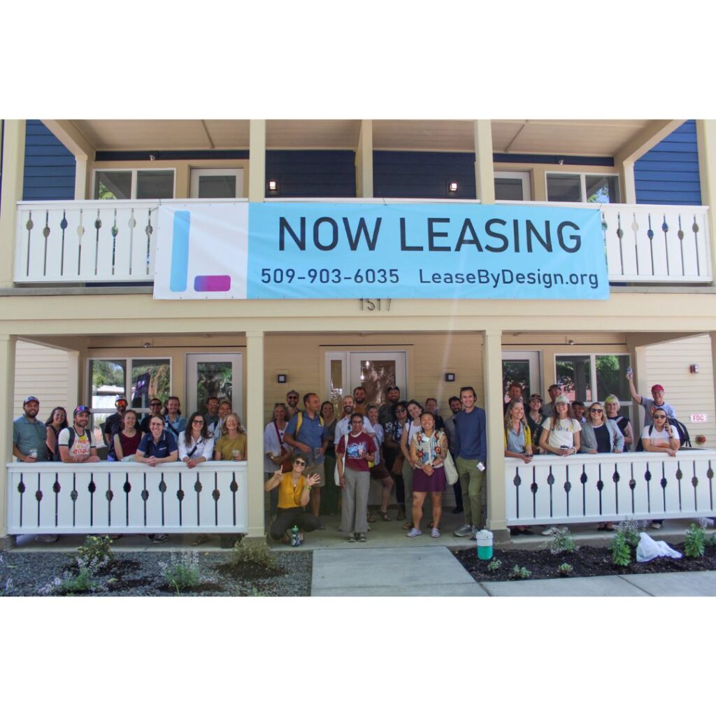 a large group of folks standing on the front porch of the newly opened six-plex in Spokane